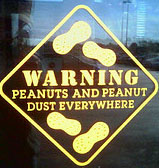 Sign that says: warning, peanuts and peanut dust everywhere
