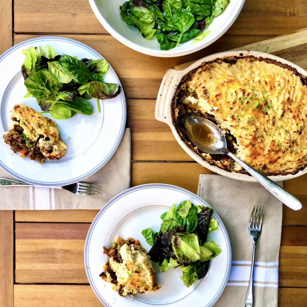 Shepherd\'s pie on plates with a green salad