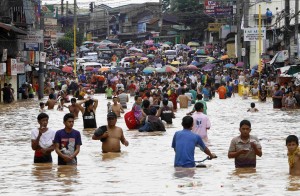Residents wade through floodwaters to return to their submerged houses in Marikina City Metro Manila